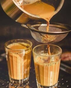 Freshly brewed Indian chai poured through a strainer into glass cups, visually explaining how digital marketing strategies for beginners are like brewing the perfect cup in digital marketing explained